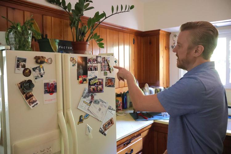 Kris Edwards points to photos of his wife, Erika“ Tilly” Edwards, who was killed in June 2025.