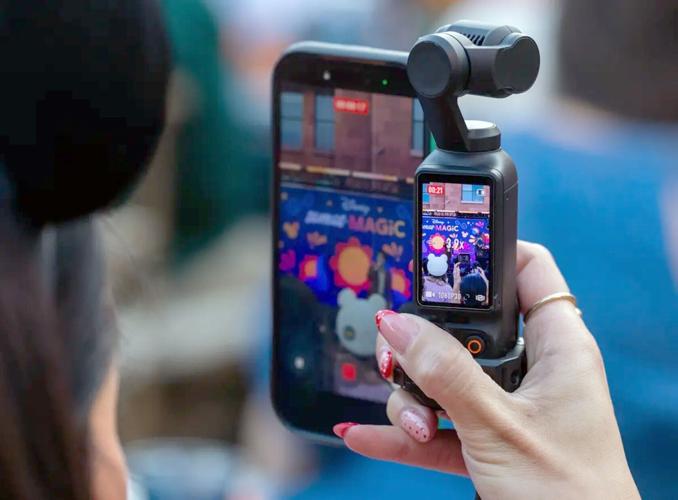 A content creator records video on their phone and DJI Osmo camera.
