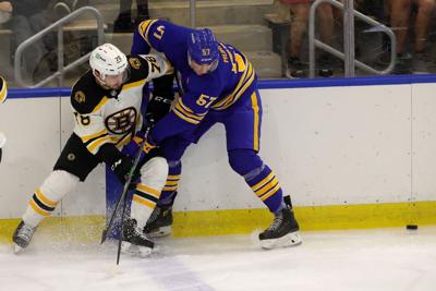 Sabres prospect left wing Brett Murray (57) gets tied up with Bruins prospect defenseman Andrew Peski (78)
