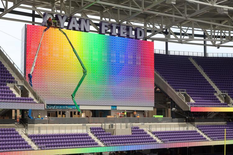 Workers make adjustments to the colorful jumbotron at Northwestern University’ s nearly finished Ryan Field on Sept. 14, 2026, in Evanston, Ill..