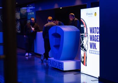 People stand at a table inside the FanDuel Sportsbook bar at the United Center during the Big Ten Men's Basketball Tournament on March 12, 2026, in Chicago.