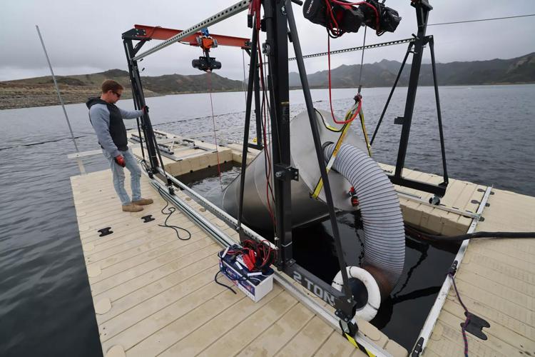 Mark Golay, director of engineering projects at OceanWell, lowers a desalination“ pod” into Las Virgenes Reservoir near Westlake Village in March 2025.