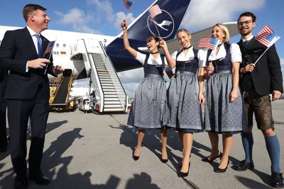 Timothy Liston, US Consul General in Munich, smiles with a Lufthansa Crew in traditional Bavarian costume next to her Airbus A 350-900 prior to a Lufthansa flight bound nonstop for Miami at Munich Airport on the first day that U.S. authorities are allow...