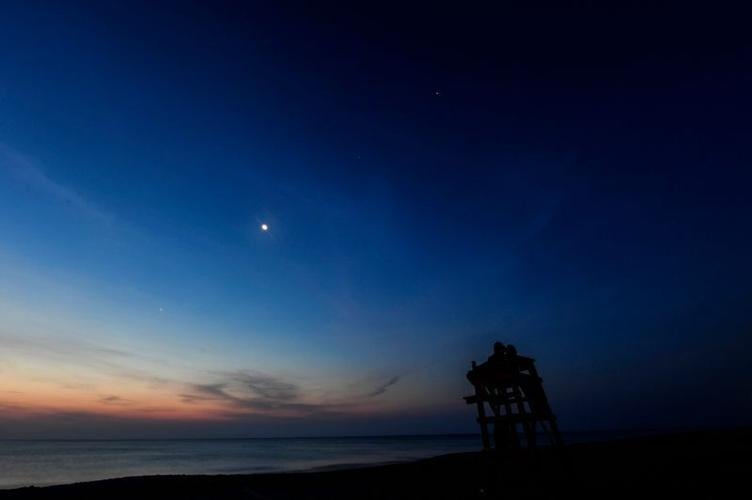 The crescent Moon joins the planets Mercury, Venus, Uranus, Mars, Jupiter and Saturn in alignment in 2022 over Melbourne Beach in Florida.