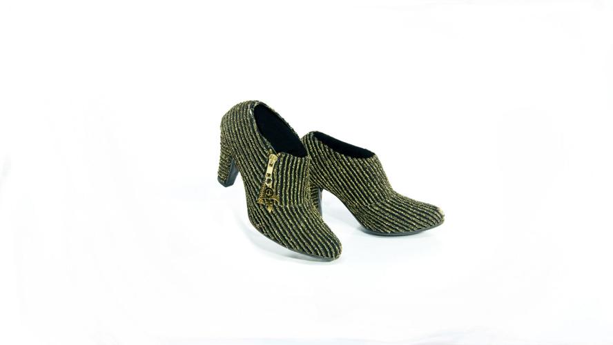 Prince wore these black shoes with gold lame stripes and Love Symbol #2 zipper pulls, along with a matching turtleneck sweater, when he and his then-wife Mayte Garcia met Prince Charles at the De Beers and Versace "Diamonds Are Forever" charity fashion ...