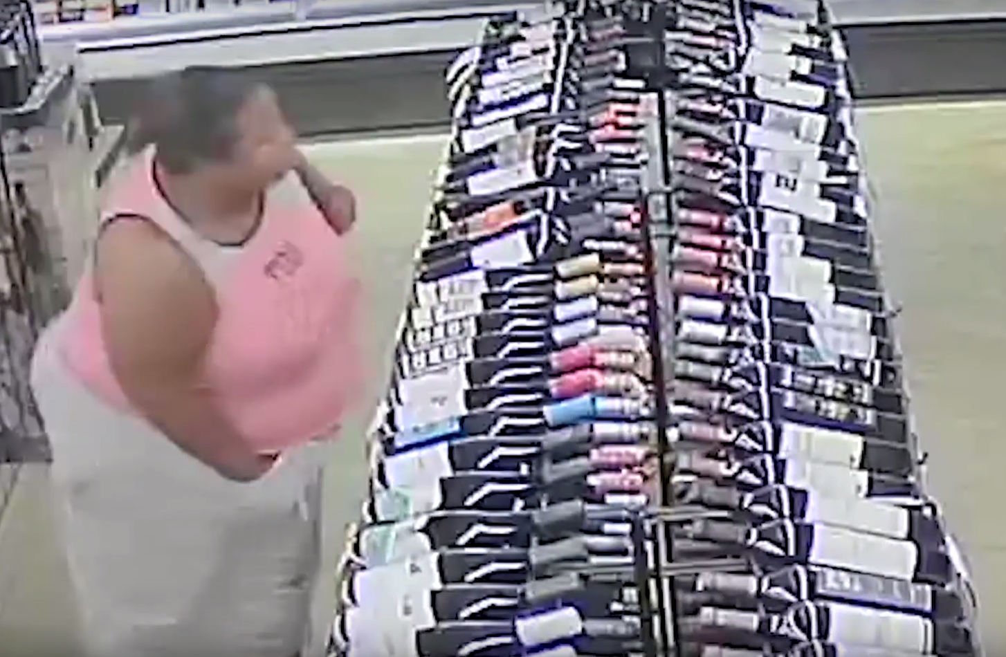 Woman appears to stash liquor bottle down trousers