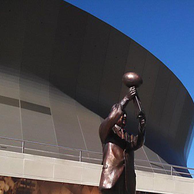 What's the story behind the Tom Benson statue outside the