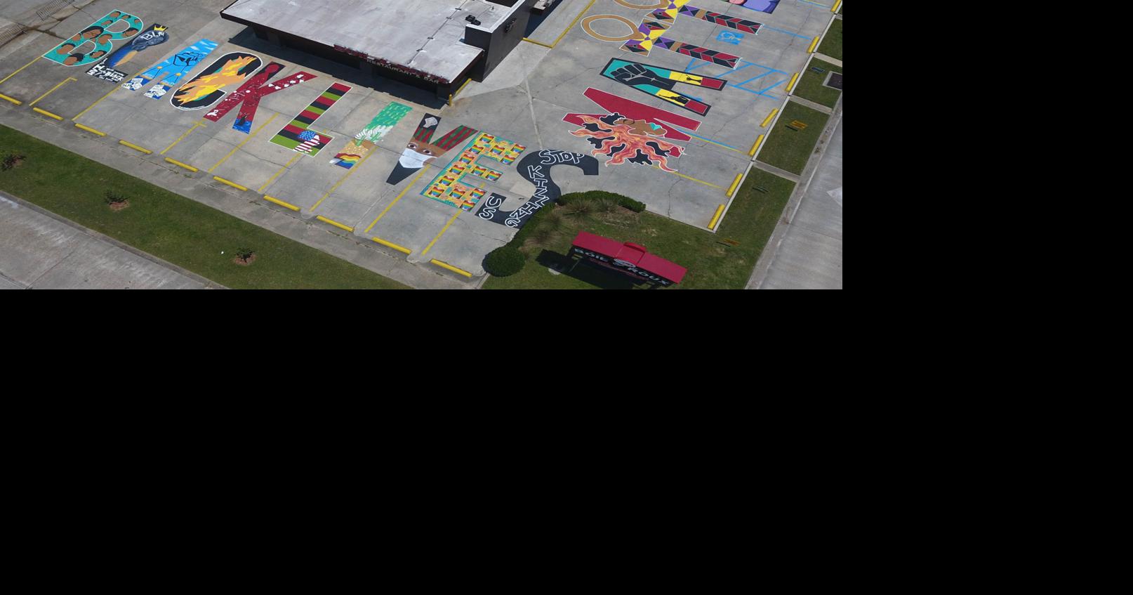 Photos A Black Lives Matter mural covers the parking lot of a Coursey