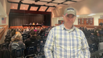 Stephen Oleszkowicz stands inside a meeting hall during a discussion on solar.