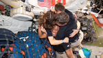 Artemis II astronauts hug inside Orion spacecraft during their return to Earth.