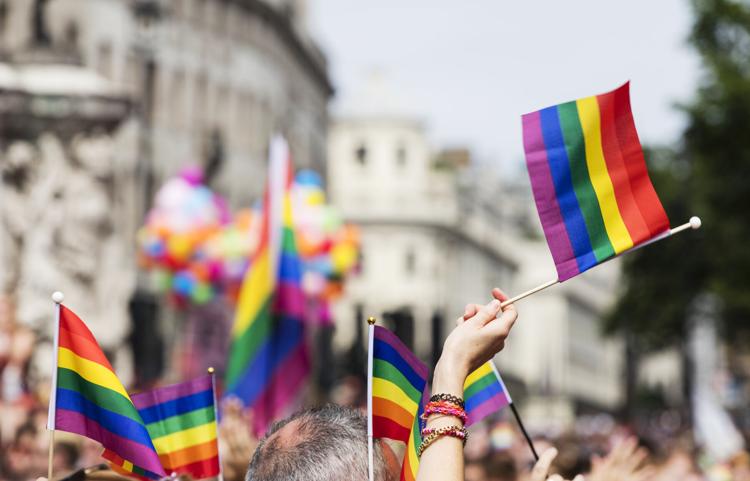 A spectator waves a gay rainbow flag at an LGBT gay pride march in London.