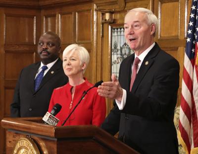 Gov. Asa Hutchinson, Labor Secretary Daryl Basset and Cindy Gillespie, director of the state Department of Human Services