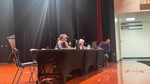 People seated at a table on stage during a Fayette Township meeting in Michigan.