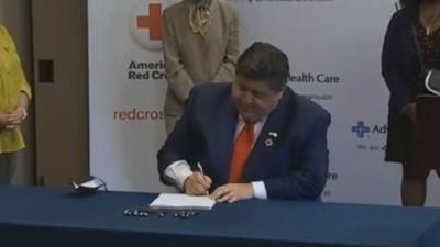 Gov. J.B. Pritzker Tuesday signs Senate Bill 2294 at an event in Downers Grove