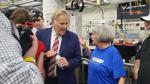 Michigan U.S. Senate candidate Mike Rogers speaks with an event attendee at the General Motors Proving Ground.