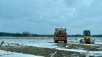 Construction equipment at a snowy solar farm site in rural Michigan.