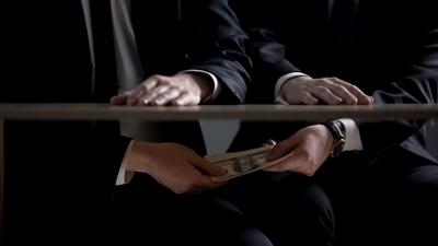 FILE - Bribery Hands Under Table Money
