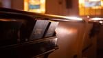 Bibles and hymnals in a church pew with sunlight streaming in.