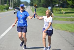 Runners pass the Peace Torch through Genesee County