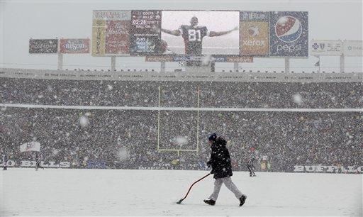 Buffalo Bills' Terrell Owens celebrates his touchdown on the replay screen  as a worker clears snow off the field during the NFL football game against  the Indianapolis Colts in Orchard Park, N.Y.