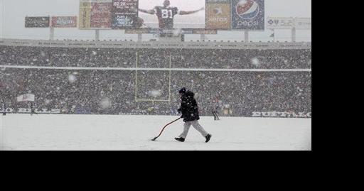 Buffalo Bills' Terrell Owens celebrates his touchdown on the replay screen  as a worker clears snow off the field during the NFL football game against  the Indianapolis Colts in Orchard Park, N.Y.