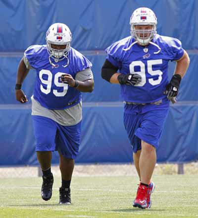 Buffalo Bills' Jerry Hughes gets his helmet stuck on teammate's jersey