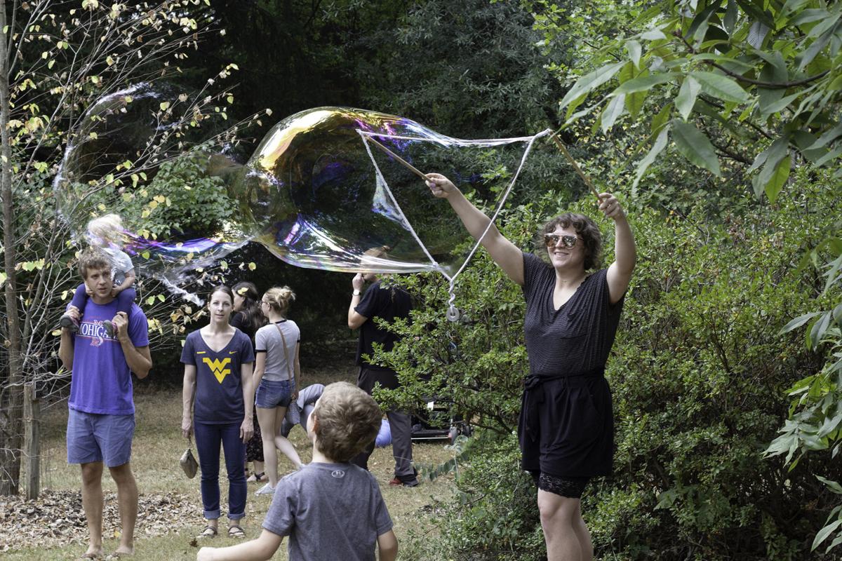 Katy Shine creates a giant bubble with her kids at the Paw Paw Festival.