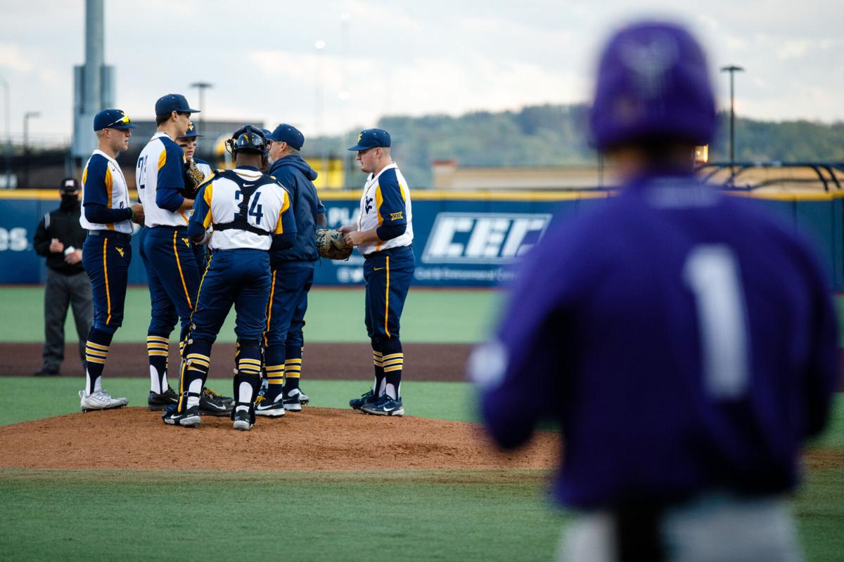 WVU players confer at the mound during West Virginia's game against the TCU Horned Frogs on April 30, 2021.