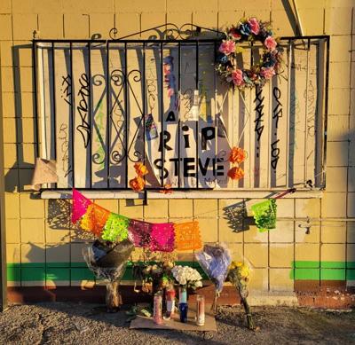 Flowers, candles under a window with a RIP Steve sign in Highland Park