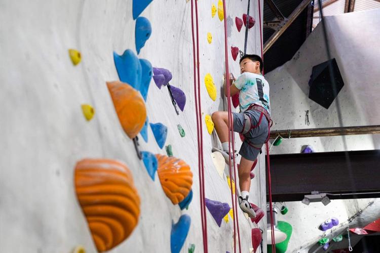 Young boy climbing an indoor rock climbing wall