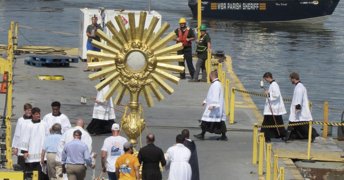 Catholic Raft Mass Hundreds line river banks for procession of boats ferrying Eucharist ...