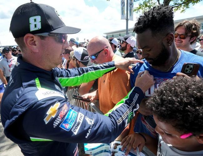 NASCAR Cup Series driver Kyle Busch (8) signs a fan’s shirt Sunday, July 27, 2025, before the Brickyard 400 at Indianapolis Motor Speedway.