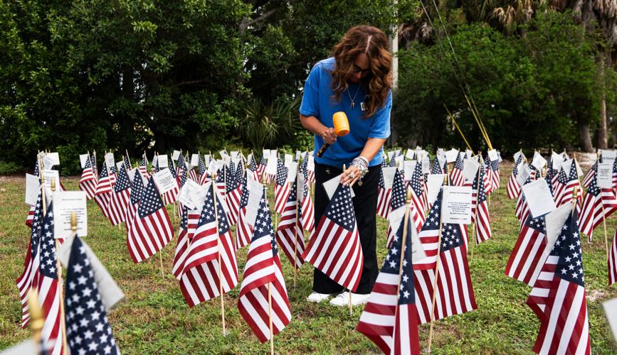Denise Dillon, marketing and event coordinator for the City of Sanibel checks on and straightens the American flags honoring