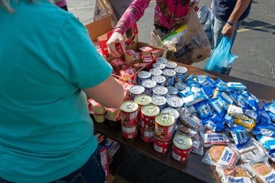 People line up for free food, groceries and clothing at the weekly Saturday River City Street Ministry food distribution on June 10, 2023, in Huntington, West Virginia. The weekly event, which is organized and run by a series of churches including relig...