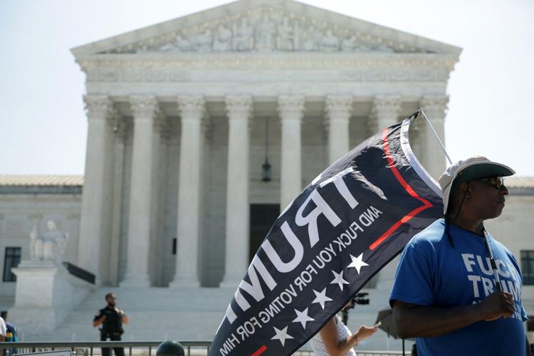 A man carries a flag in front of the U.S. Supreme Court on June 30, 2026, in Washington, D.C. Today, the U.S. Supreme Court struck down a ban on birthright citizenship, upheld state restrictions on transgender athletes in female sports and eliminated fe...