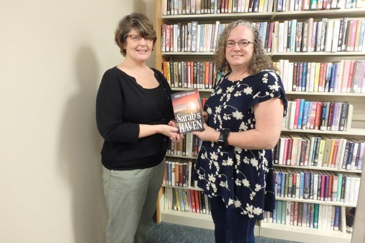 Sarah Holley donates Sarah's Haven to library by back wall  10-26-21 (2).JPG