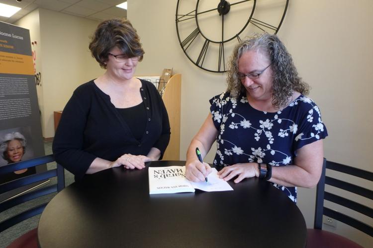 Sarah Holley signs Sarah's Haven to gift to library  10-26-21 (2).JPG