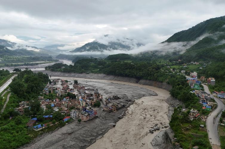 A drone view shows mud covering properties following a flash flood in Trishuli
