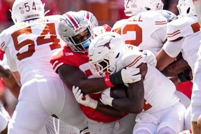 Ohio State Buckeyes defensive lineman Kayden McDonald (98) tackles Texas Longhorns running back CJ Baxter (4) during the NCAA football game at Ohio Stadium on Aug. 30, 2025.