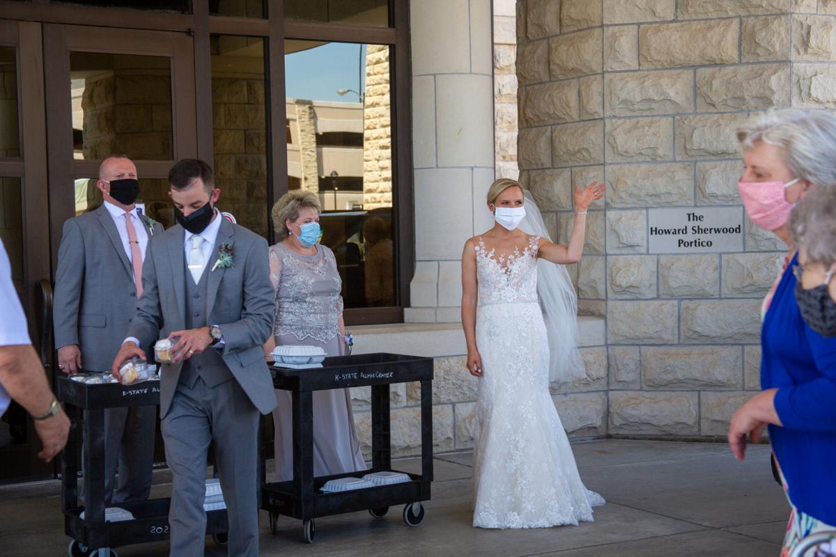 Bride Brittany Murrell waves at oncoming guests at wedding reception. Brittany Murrell and Matthew Lorson held reception at the Alumni center hosting a “drive by wedding” where guests could say their congratulations in the safety of their cars.