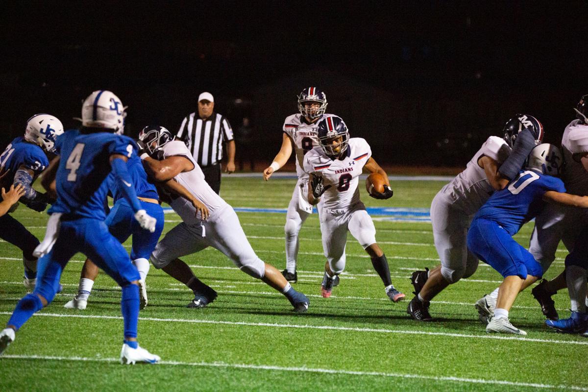 Running back Vincent Smith, junior, finds a gap and pushes forward. Manhattan High Indians went head to head against the Junction City Bluejays on Friday night at Al Simpler Stadium with a final score of Junction City 36, Manhattan 29.
