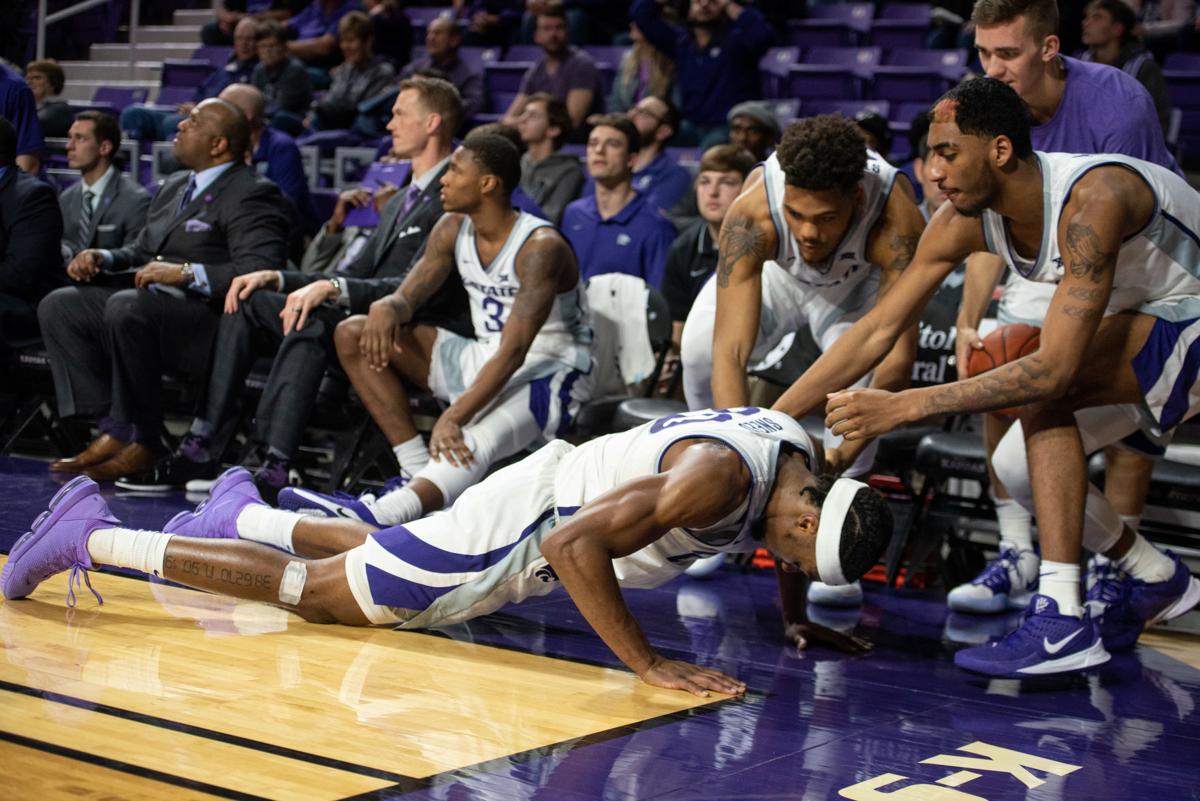 Xavier Sneed (20) lies on the ground in front of his bench after trying to dive for Cartier DiarraÕs pass that went out of bounds with under a minute left on the clock.