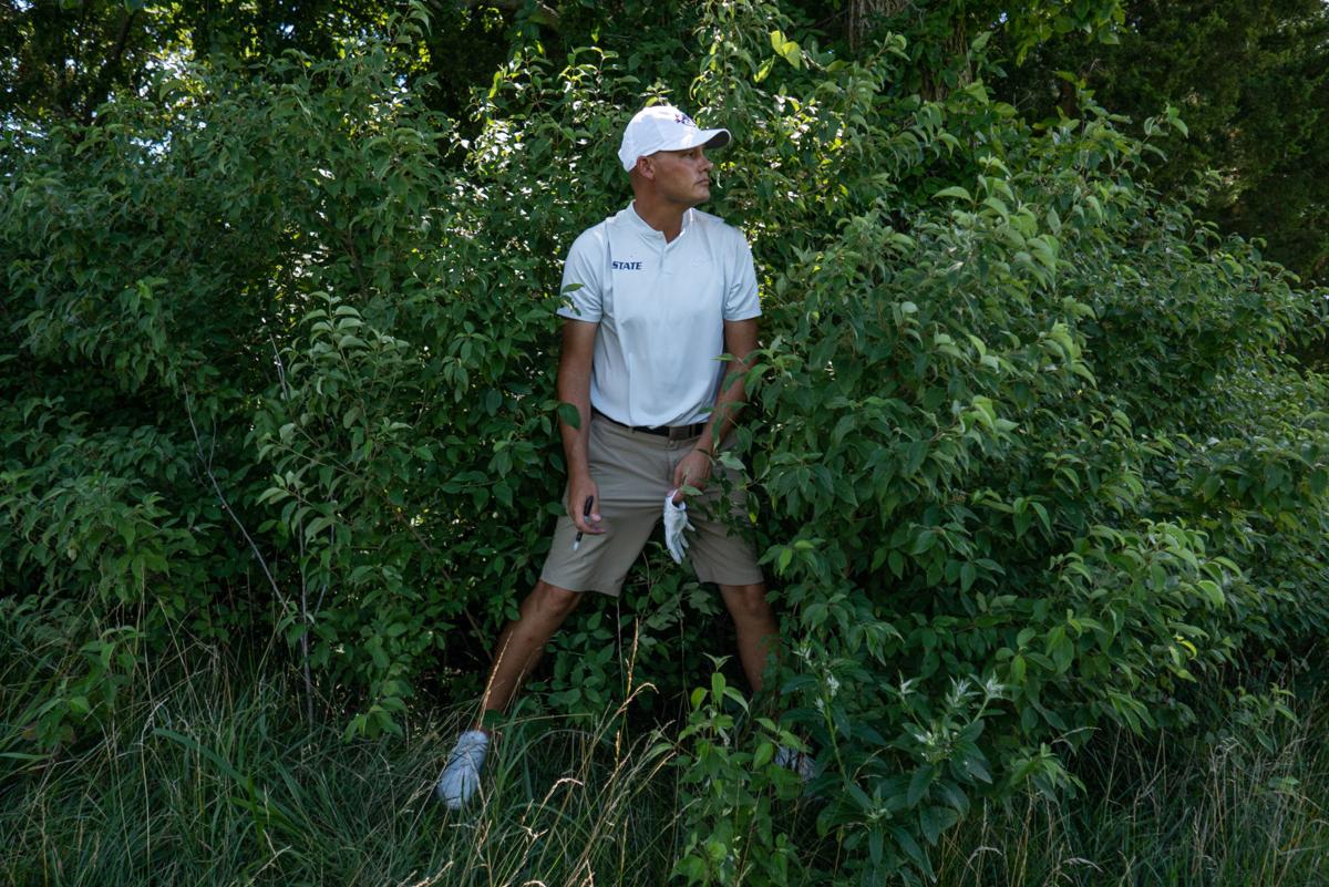 Jared Helin practices his swing in the rough on Hole 15 but decides to drop a new ball instead of dealing with the shot.