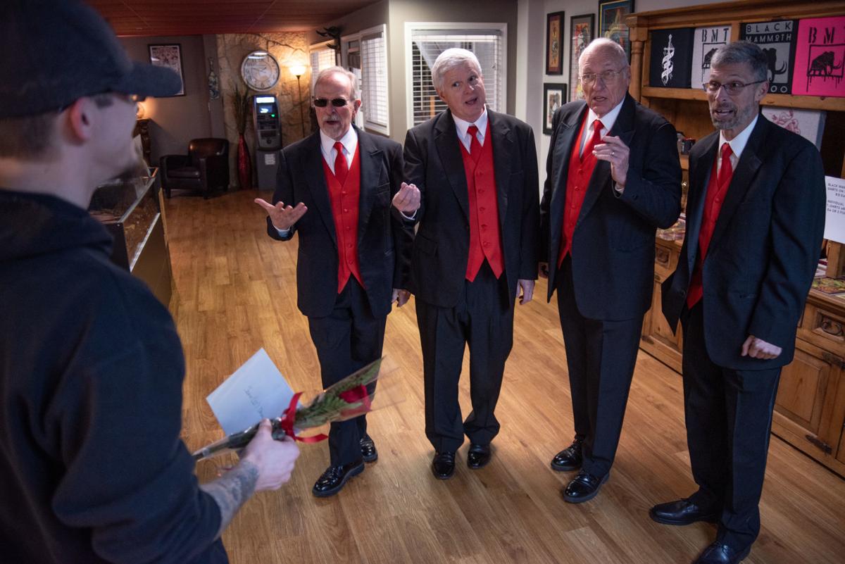 John Dahl listens to Ken Garwick, Steve McKinzie, Leonard Purvis and Tom Fish deliver his Singing Valentine while working at Black Mammoth Tattoo on Thursday. DahlÕs wife ordered the Singing Valentine for him.