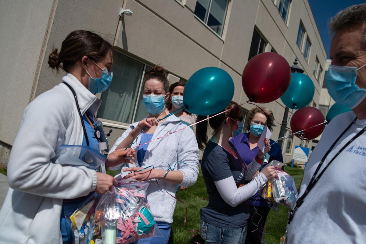 From left, Jessica Wolfe, Tiffany Erickson, Melinda Couch, Jennifer Goehring and Bob Copple say their goodbyes outside of Ascension Via Christi Hospital before Wolfe and Couch leave for Chicago on Sunday to assist in battling COVID-19 at another Ascension Via Christi location.