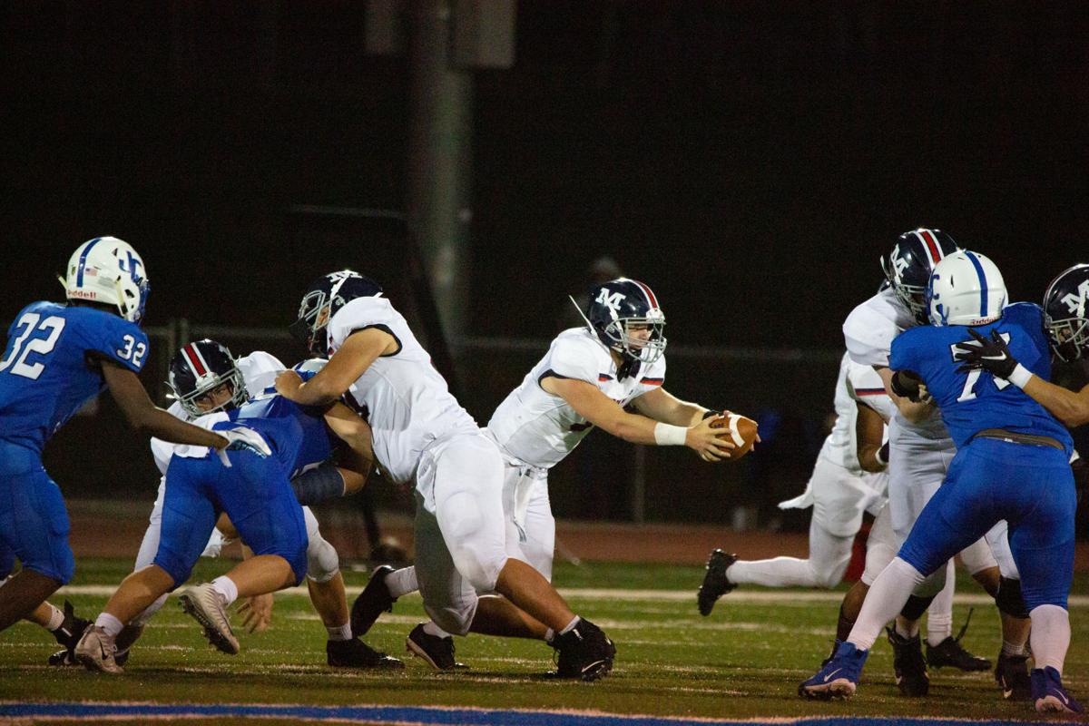 Quarterback Dayne Aschenbrenner, senior, hands off the ball giving an opening for Manhattan. Manhattan High Indians went head to head against the Junction City Bluejays on Friday night at Al Simpler Stadium with a final score of Junction City 36, Manhattan 29.