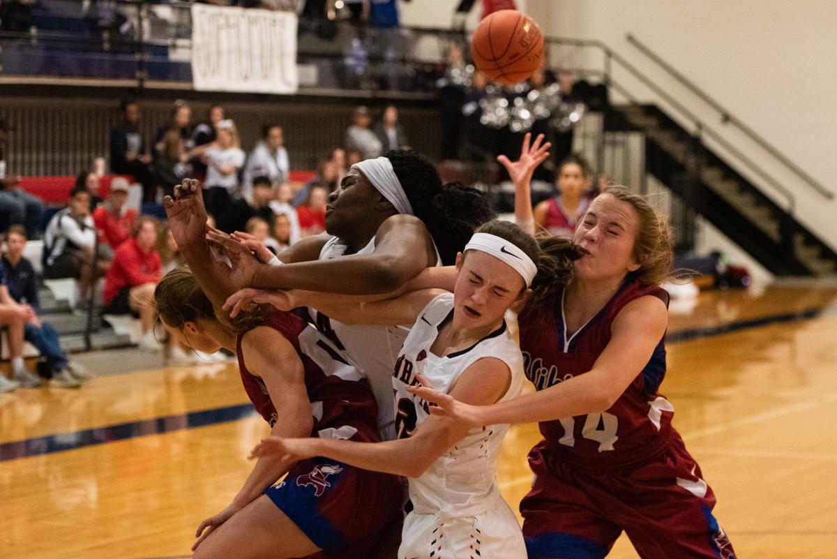 Raigan Kramer (00), Zanaa Cordis (44), Amellia Knopp (12) and Riley Cowan (14) run into one another under the hoop after Knopp attempted a lay-up.