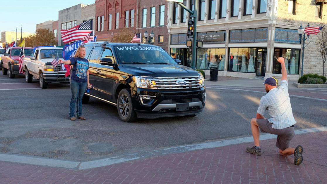 Man who knelt said he ‘had to do something’ when he saw QAnon symbols in parade