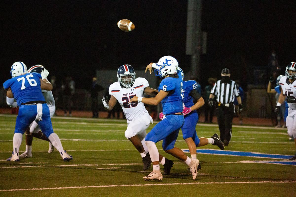 Junction City’s (number 6) passes away as DaShawn Edwards, junior, moves in for a tackle. Manhattan High Indians went head to head against the Junction City Bluejays on Friday night at Al Simpler Stadium with a final score of Junction City 36, Manhattan 29.