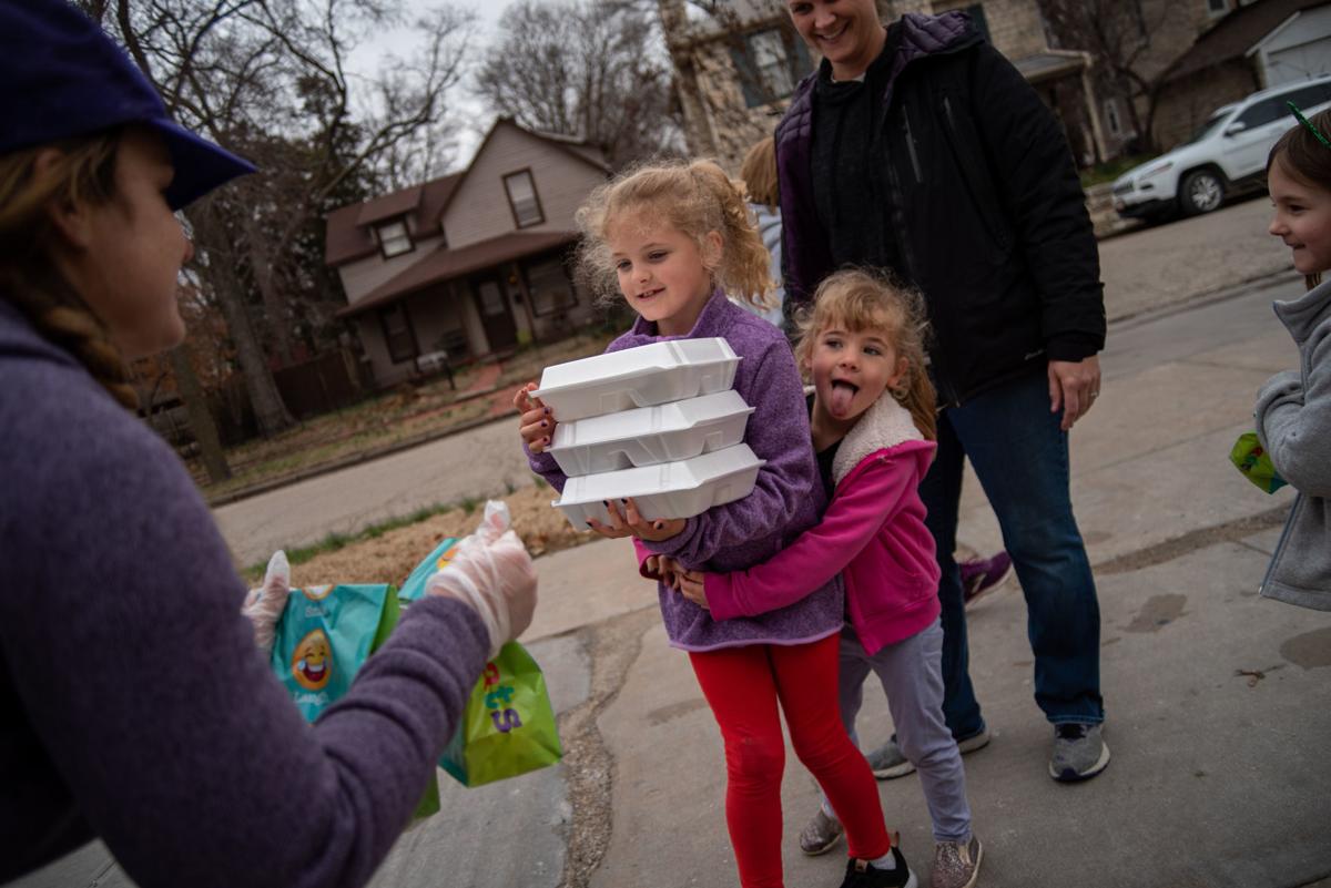 Brooke Snyder gives Corabelle Stamey (middle) to-go lunches while Iris Stamey (middle right) wraps her arms around Corabelle.